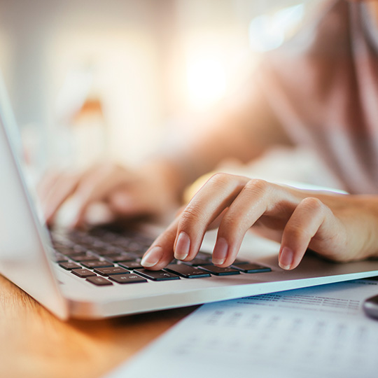close up of hands typing on a keyboard